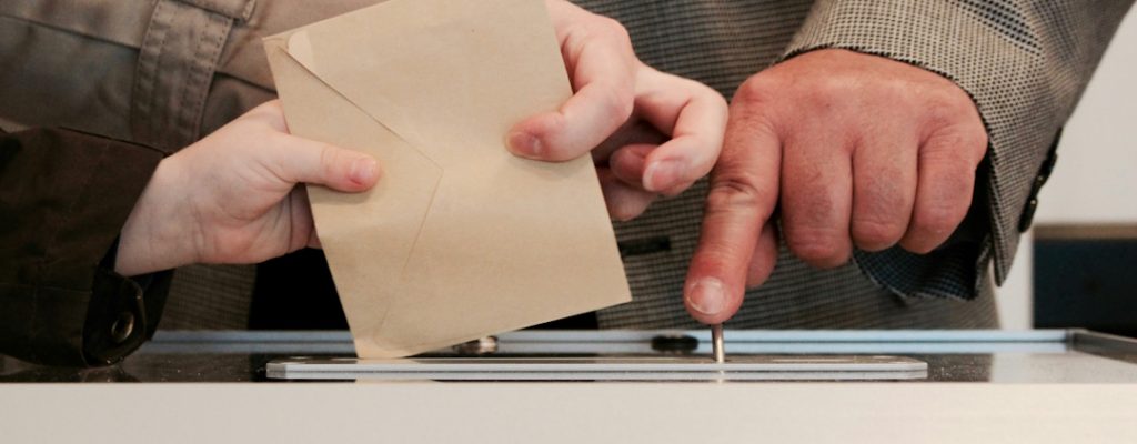 someone voting at a ballot box