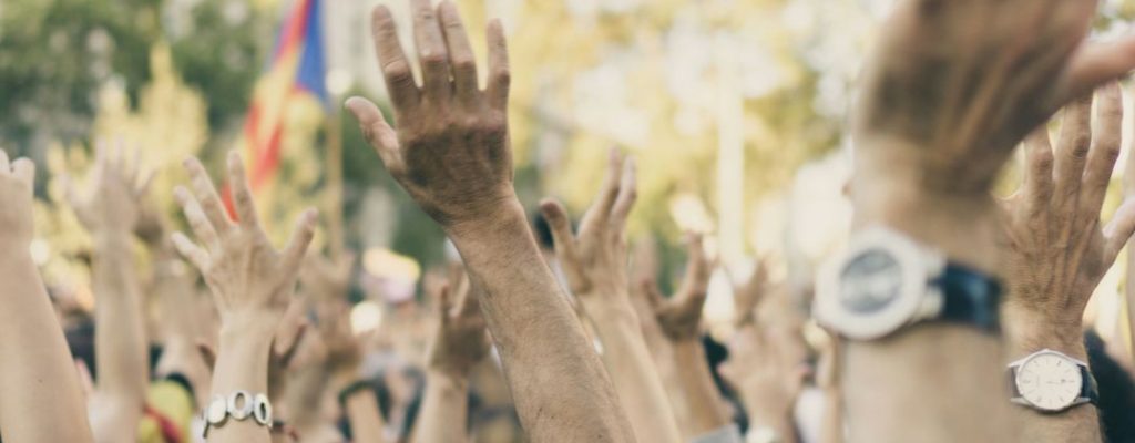 hands raised on the street in the sun
