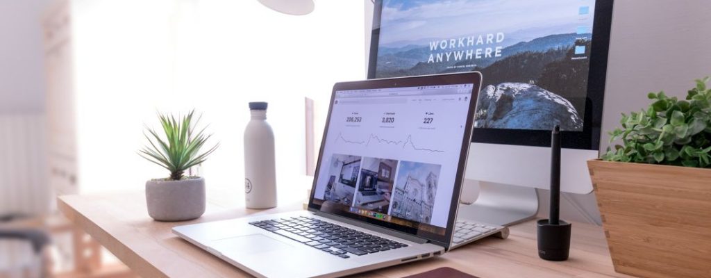 a laptop and screen on a desktop