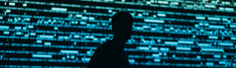 a silhouette of a man in fron of computer code